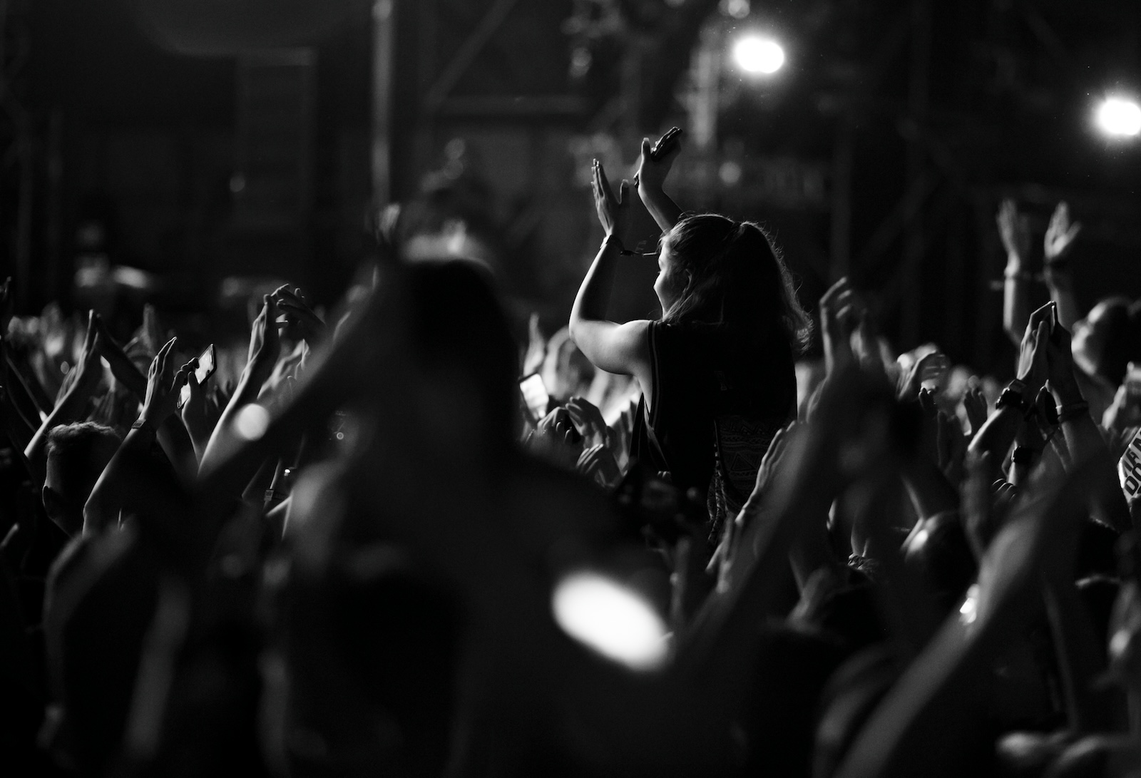 Black and white photo of crowd having fun at music festival by night. Martyn's Law